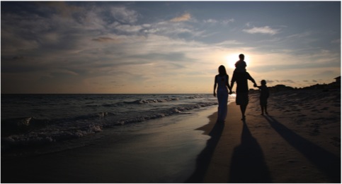 Young family On Beach In Sunset